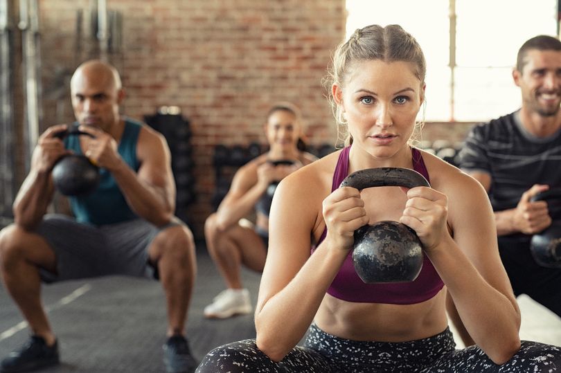 Lad at the gym put in awkward position as female friend squats in front of him