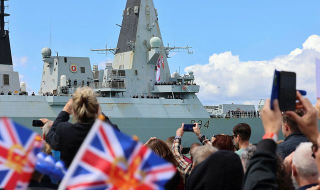 Warship returns after landmark trip – but helicopter issue means defence secretary misses the action