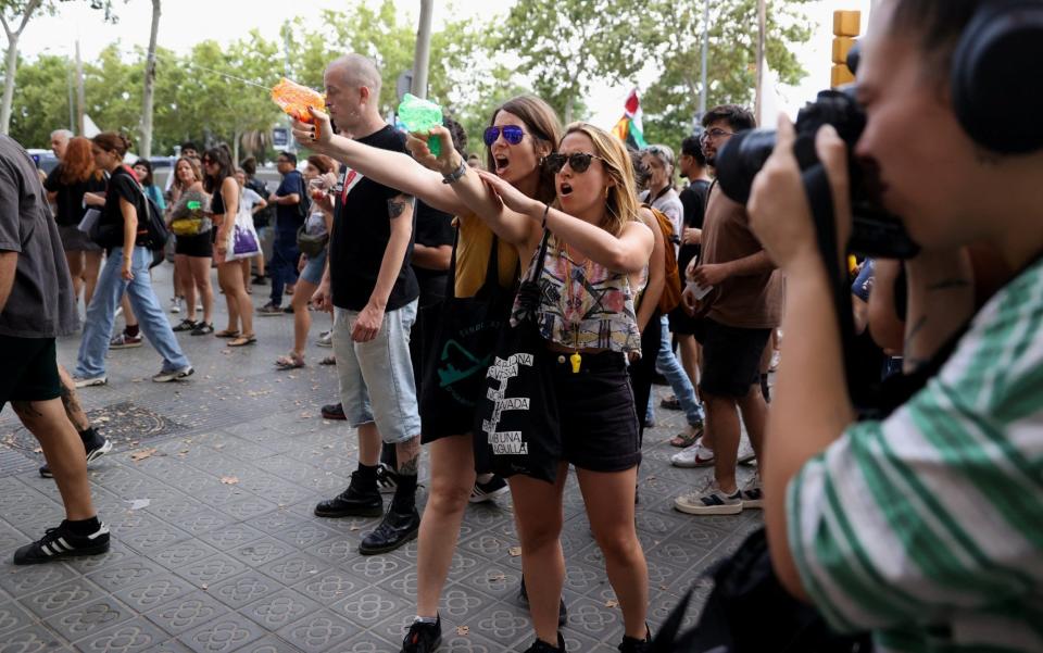 Watch: Protesters soak dining tourists with water pistols