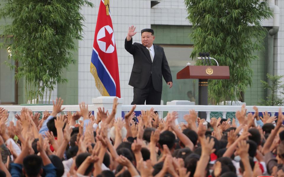 Beaming Kim Jong-un surrounded by flood-stricken North Korean children grasping for food