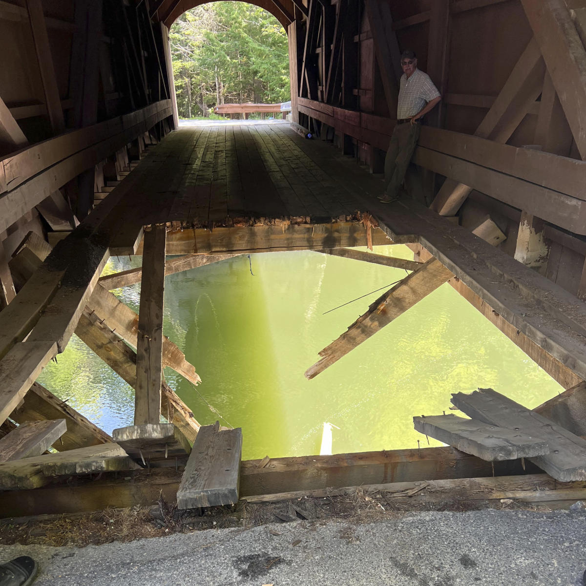 Dump truck leaves hole in covered bridge when it crashes into river in Maine