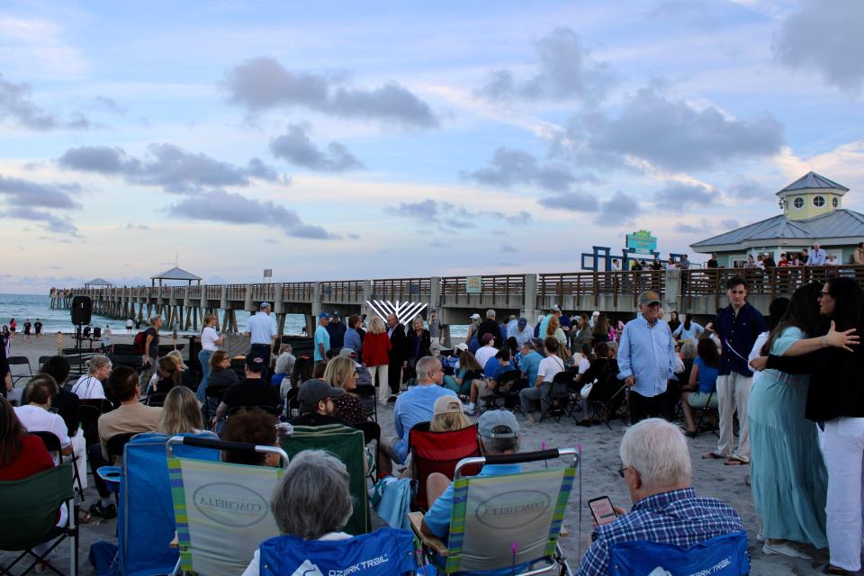 Night of triumph: Crowd cheers lighting of sand-sculpted menorah during Hanukkah on Juno Beach