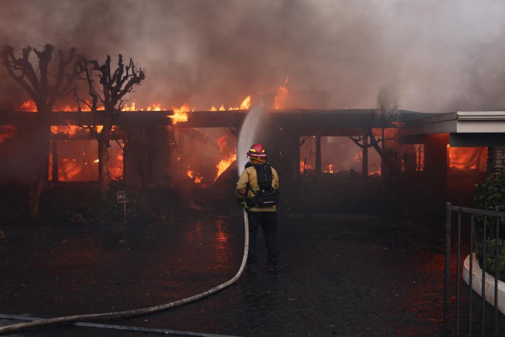 Fast-moving wildfire destroys homes as strong winds hit southern California