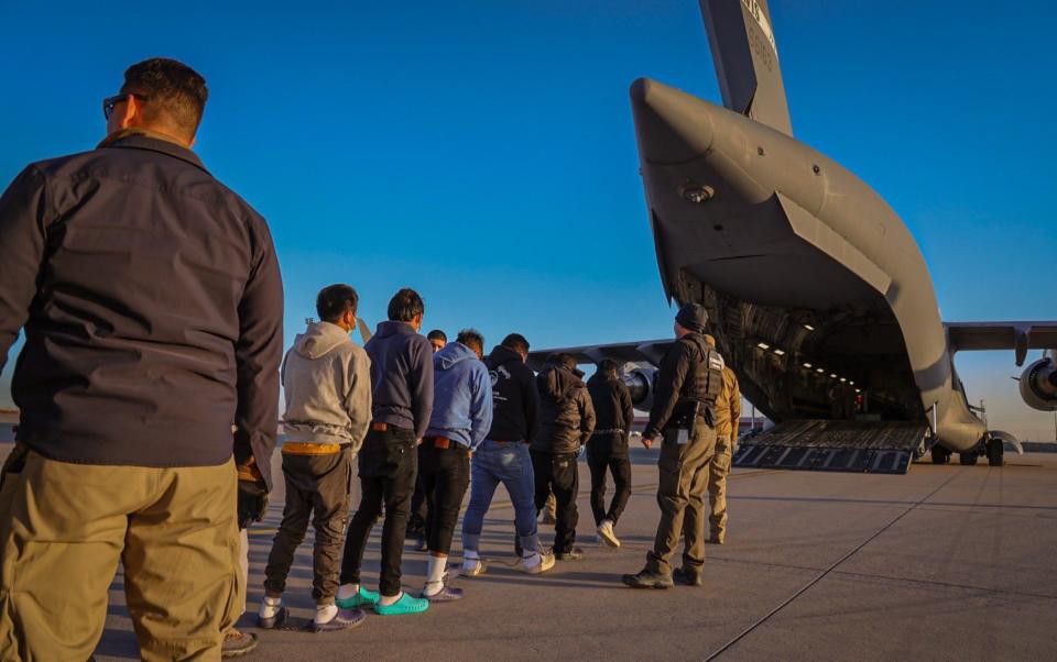 Shackled migrants marched onto military plane after Trump orders deportation crackdown